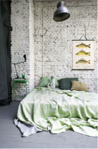 Witte bakstenen muur achter bed