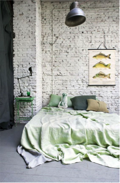 Witte bakstenen muur achter bed